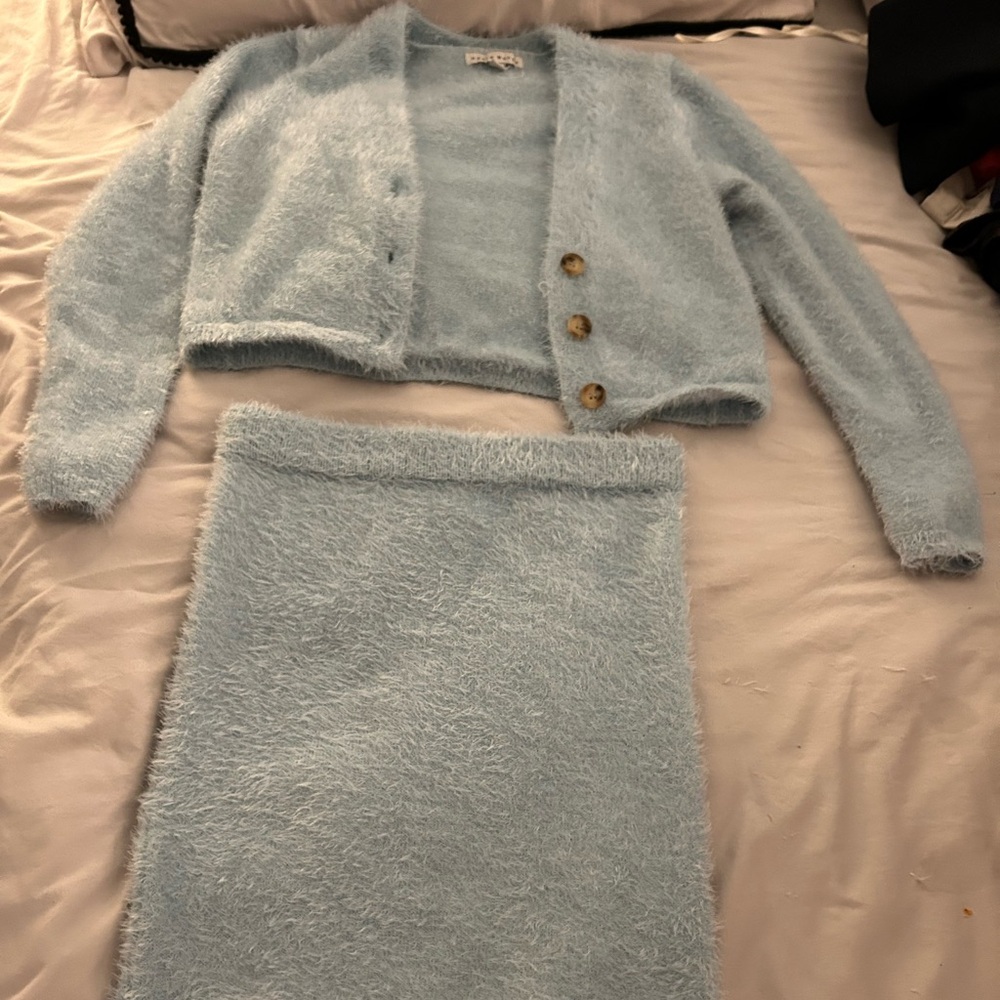 It’s a 3 piece baby blue warm set. Sweater, crop top and skit.